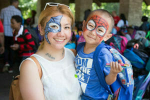 One family models the face painting provided by volunteers at this year's Wells Fargo Backpack Giveaway, held at North Mississippi Regional Park