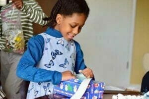 Image showing a child opening a present.