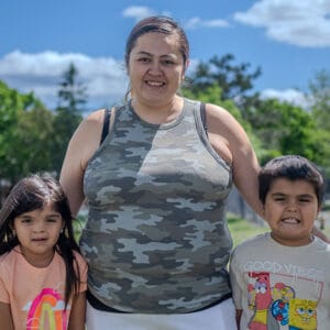 Megan, a successful participant in Avivo's programs, poses for a photo with her children.